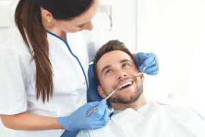 Man having teeth examined at dentists. Overview of dental caries prevention