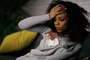 Sick woman at home. Young african woman laying on sofa she is si